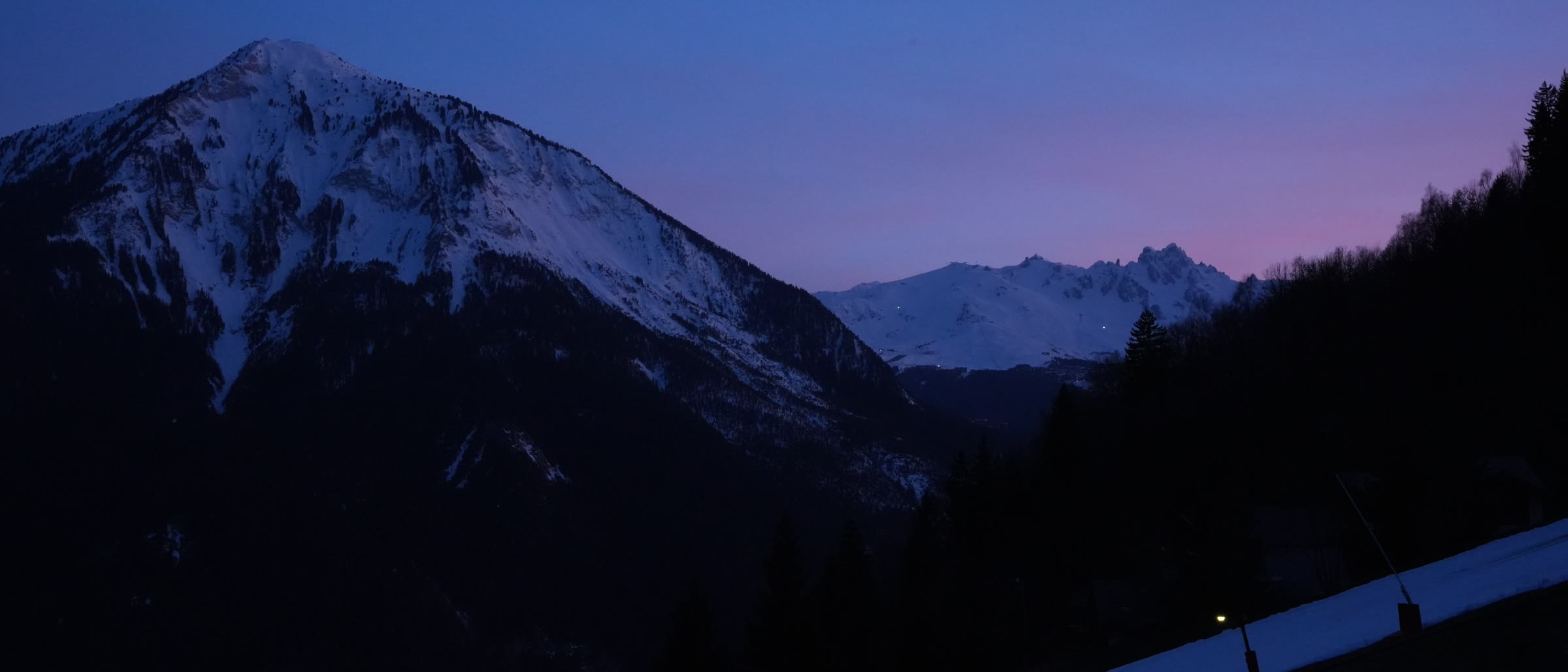 Snowed alpine peaks at dusk under a violet sky